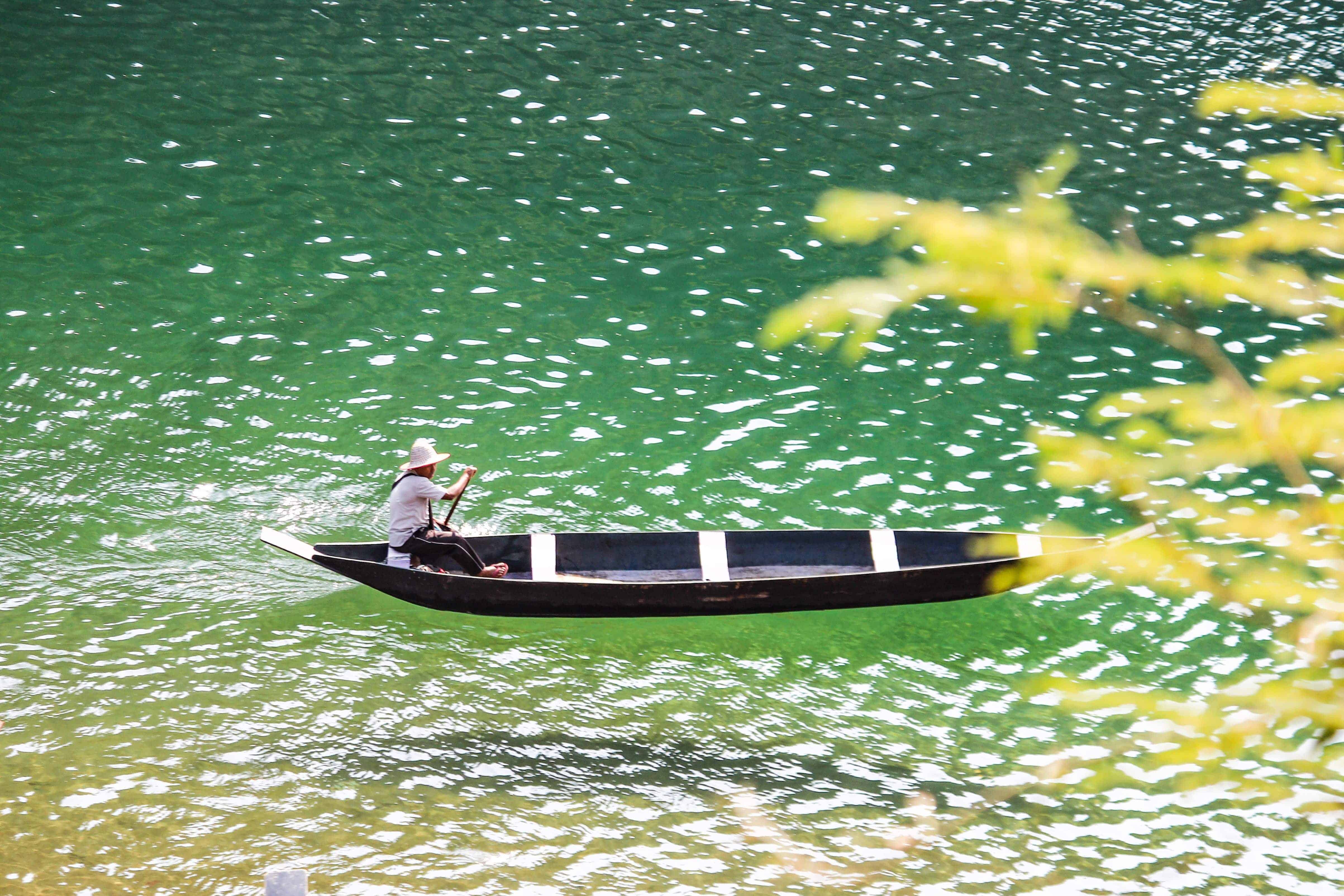 A boatman rowing on Umngot river